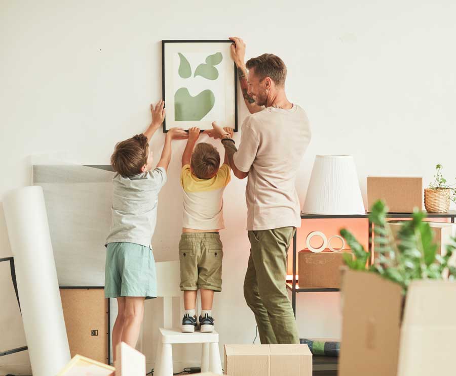 Happy family hanging pictures in their new home